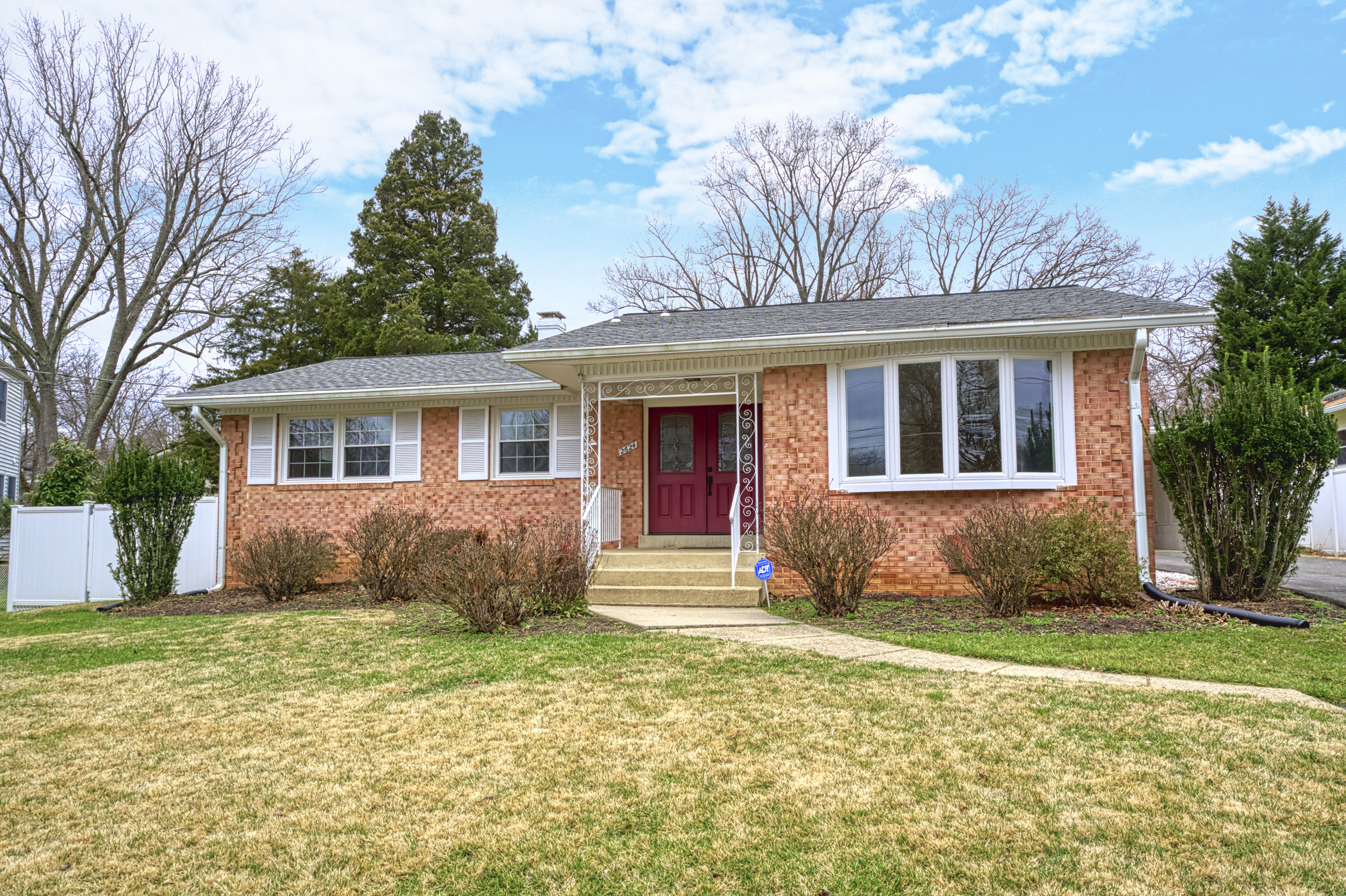 Professional exterior photo of 2624 Depaul Dr in Vienna, VA - showing the front of a brick ranch home with covered front porch and white shutters and window framing