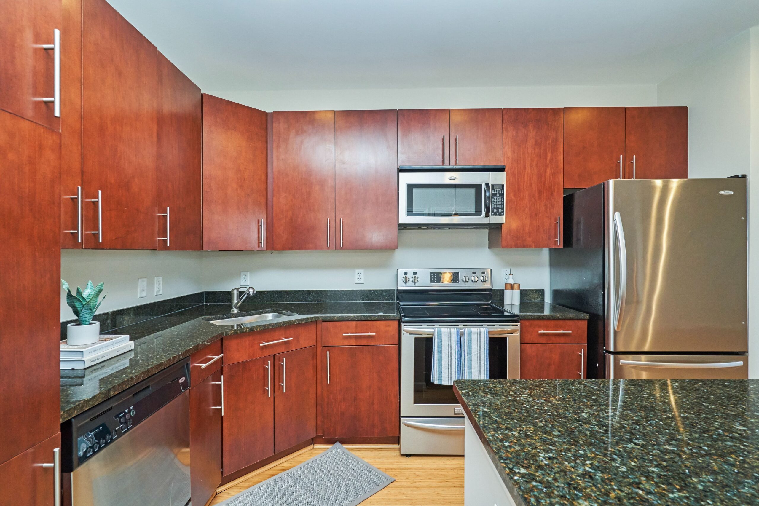Professional interior photo of 444 W Broad St Unit 631 - showing the open kitchen with island and granite counters, stainless appliances, and lots of cupboards