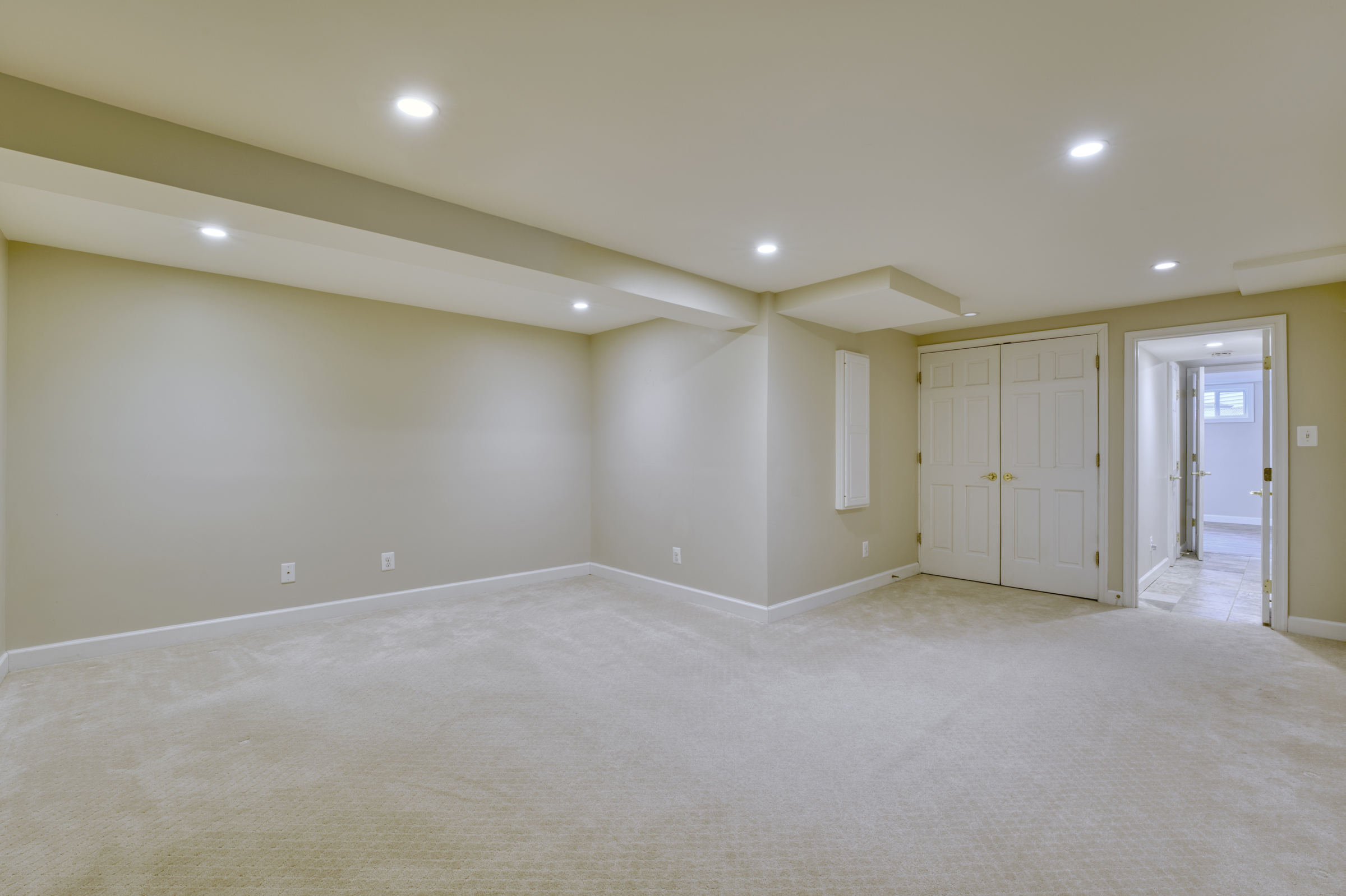 Professional interior photo of 2624 Depaul Dr in Vienna, VA - showing the main area in the fully finished basement with beige carpeting and looking back to a fully bathroom