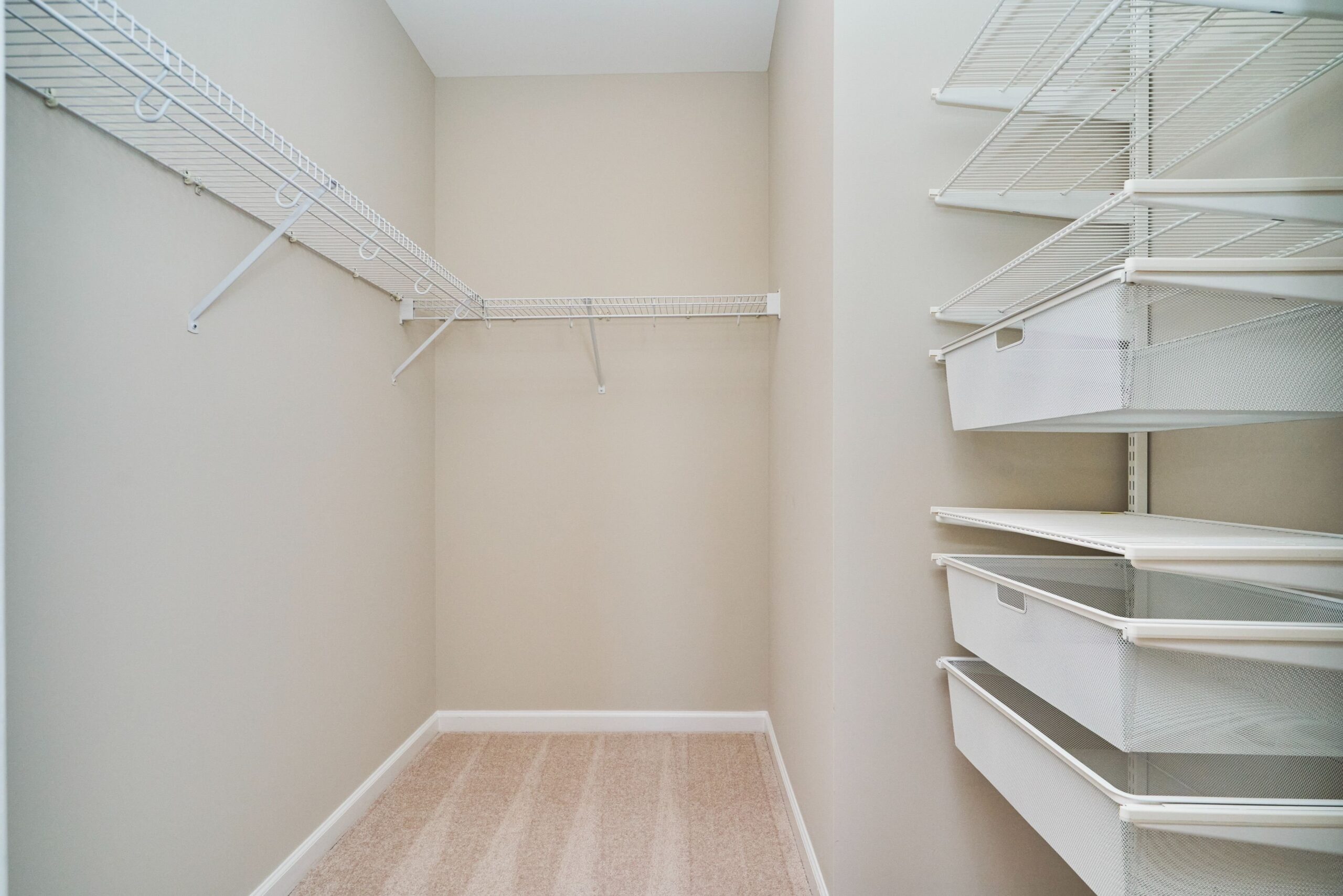 Professional interior photo of 444 W Broad St Unit 631 - showing one of the walk in closets with wire clothing rack in L shape and several wire shelves with under-drawers