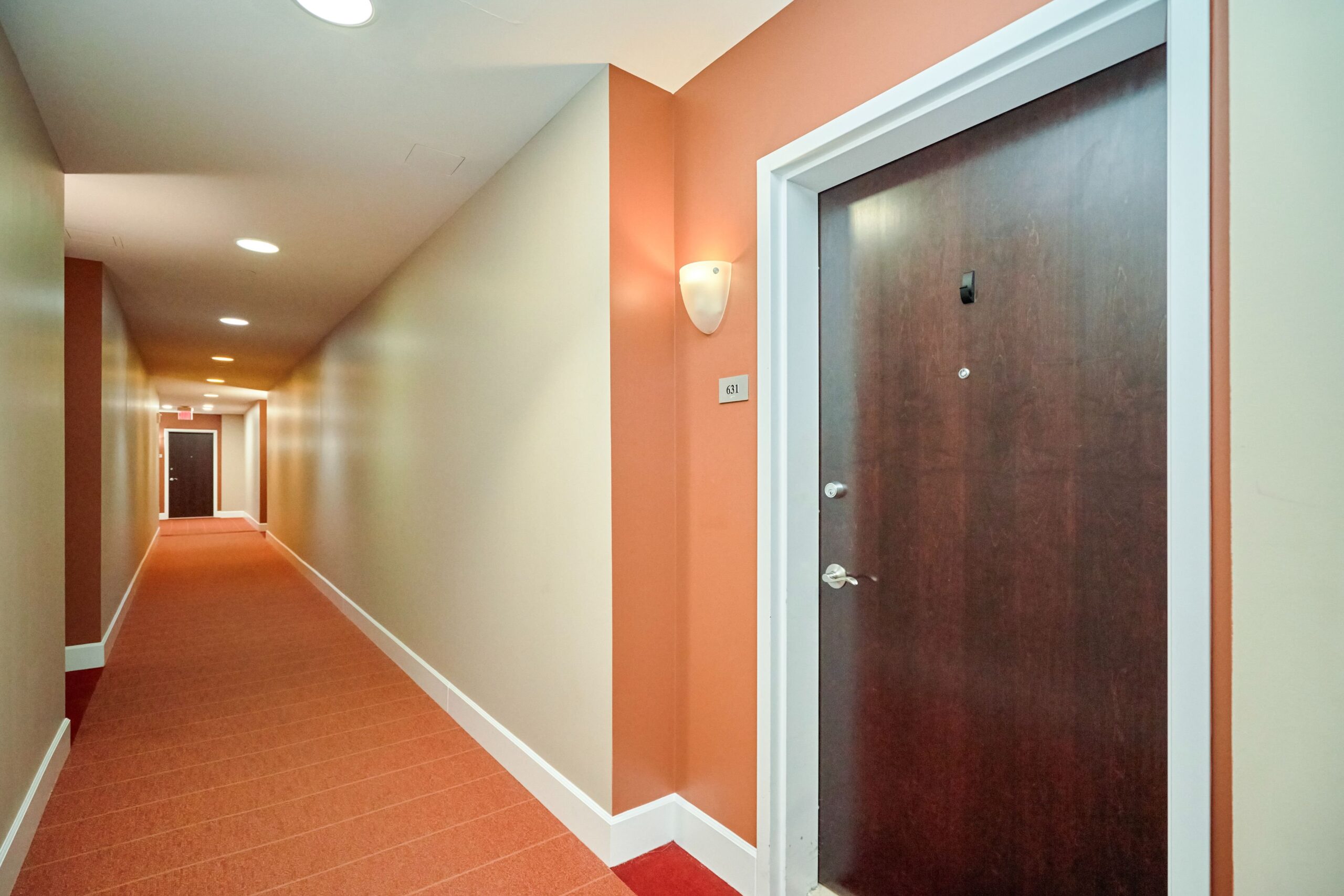 Professional interior photo of 444 W Broad St Unit 631 - showing the exterior hallway and dark wood front door