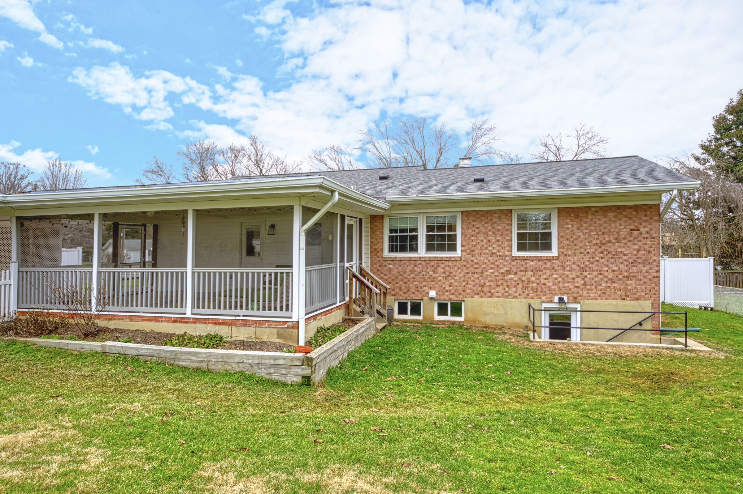 Professional exterior photo of 2624 Depaul Dr in Vienna, VA - showing the rear of a brick ranch home with screened porch and stairs down to lower level